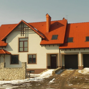 Класичний будинок із бежевою штукатуркою баранек на фасаді фото